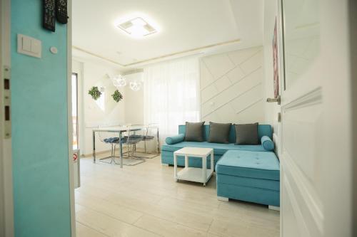 a living room with a blue couch and a table at Apartmani SLEEP&JOY in Zlatibor