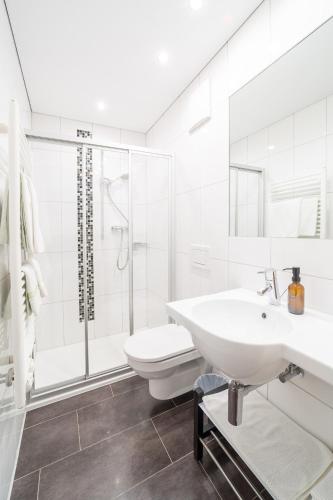 a white bathroom with a sink and a toilet at Haus Schönlechner in Gaschurn