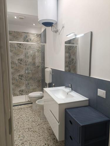 a bathroom with a sink and a toilet and a mirror at Sant' Agostino Suite in Trapani