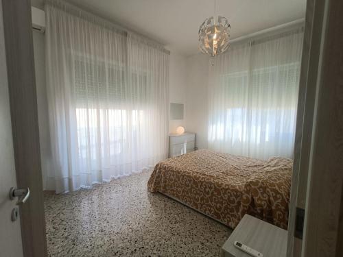 a bedroom with a bed and a chandelier at Sant' Agostino Suite in Trapani