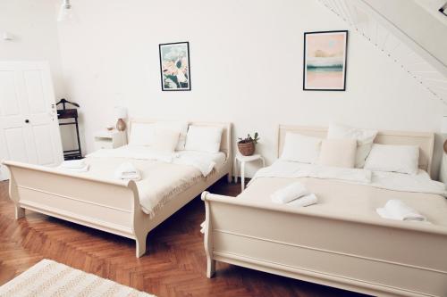 two beds in a room with white furniture at The sanctuary ljubljana in Ljubljana