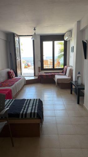 a large room with two beds and a living room at Athos Cape Traditional House in Pyrgadikia