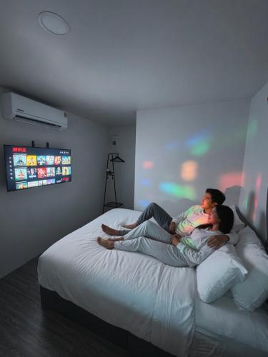 a woman and a woman laying on a bed with a baby at Cloud Bed Ao Nang- High Speed internet, Comfort bed , Smart Tv in Ao Nang Beach