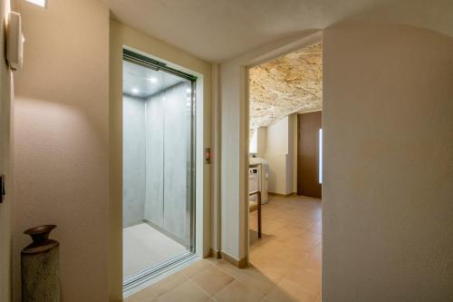 a hallway with a glass door leading to a bathroom at Cannn Patllari de Corts I II in Cornellá de Terri