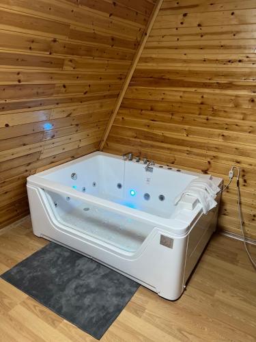a bath tub in a room with a wooden wall at Bujtina Panorama Kir in Kashec