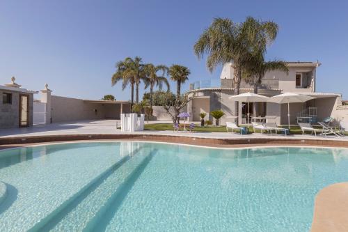 a large swimming pool in front of a house at Aqua Suites Doria in Syracuse