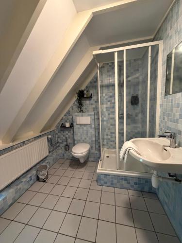 a bathroom with a sink and a toilet at Hotel Ter Linde in Zuidwolde