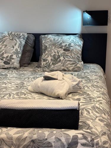 a unmade bed with a white towel on it at Studio Cocon & Bulle in La Côte-Saint-André