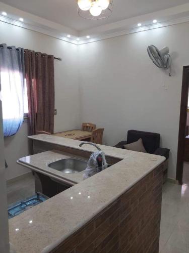 a kitchen with a sink and a living room at Qasr Diana in Marsa Matruh