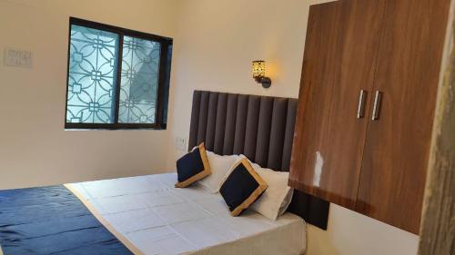 a bedroom with a bed and a window at Sahil Private Pool Villa in Alibaug