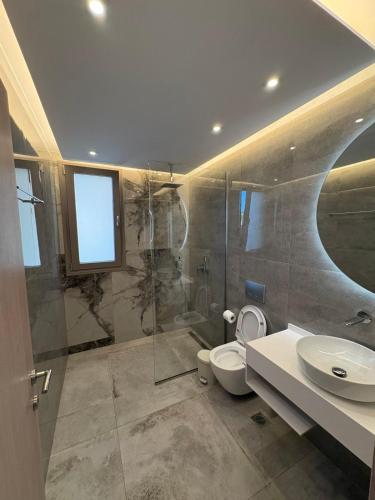 a bathroom with a shower and a toilet and a sink at Calm Luxury Villas in Limenaria