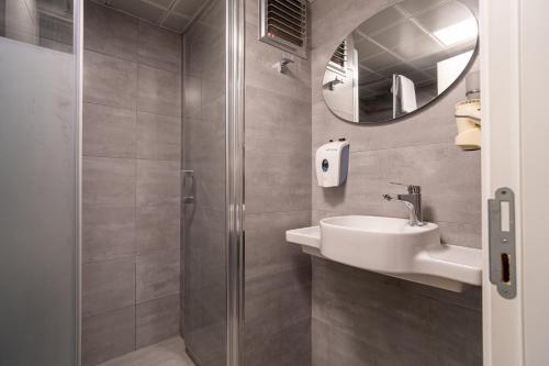 a bathroom with a shower and a sink and a mirror at May park HOTEL in İzmir