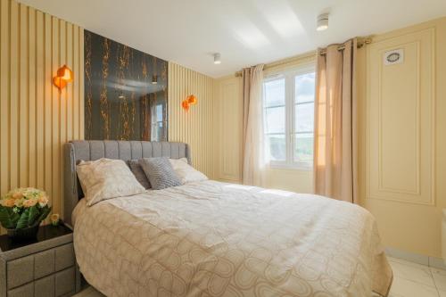 a bedroom with a large bed and a window at Villa layra Havre de paix Haute de Gamme in Goussainville