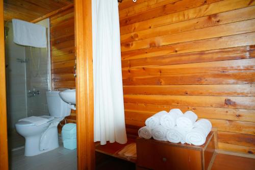 a bathroom with a toilet and a bunch of towels at Angels Garden Hotel in Olympos