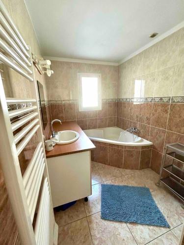 a bathroom with a tub and a sink and a bath tub at Large Family Chalet Mountain Views in Olette