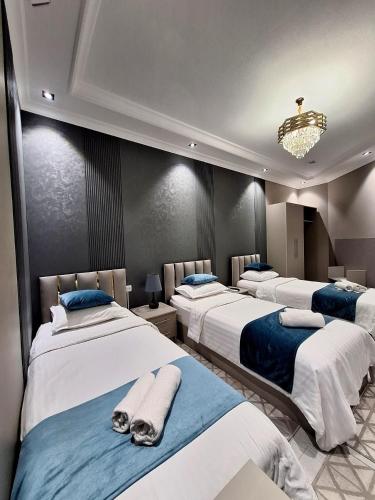a room with three beds with towels on them at Light guest house in Samarkand