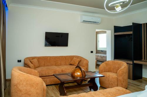 ein Wohnzimmer mit einer Couch, zwei Sesseln und einem Tisch in der Unterkunft Hotel Vila Stefa in Vlorë