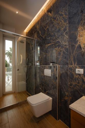 a bathroom with a toilet and a glass shower at Trevi Hotel & Restorant, Shengjin in Shëngjin