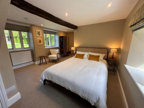 a bedroom with a large bed and a chair at Hinton Hayloft in Hinton in the Hedges
