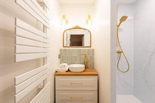a bathroom with a sink and a mirror at L'Apothicaire 2 Chambres - Piscine in Montaigu-Vendée