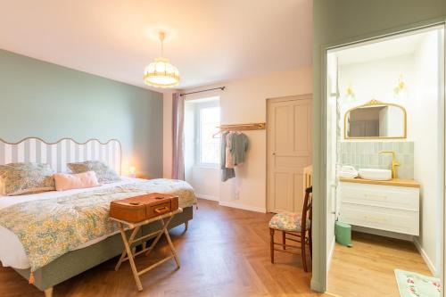 a bedroom with a bed and a dresser and a mirror at L'Apothicaire 2 Chambres - Piscine in Montaigu-Vendée