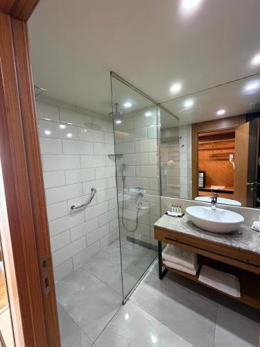 ein Badezimmer mit Waschbecken und Glasdusche in der Unterkunft Windyhill Hotel in Elâzığ