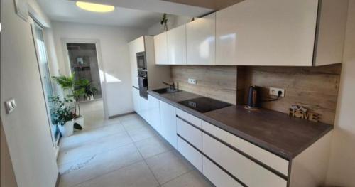a kitchen with white cabinets and a counter top at Soukromý pokoj pro 2 se sdílenou koupelnou a kuchyni Bezručova in Hradec Králové