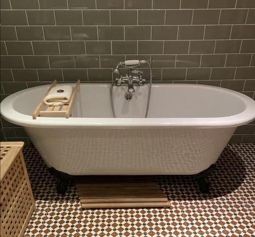 a white bath tub sitting in a bathroom at Harris Cuckoo Cottage in Luskentyre