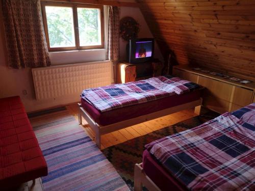 a room with two beds and a television in a cabin at Chata Panorama in Čremošné