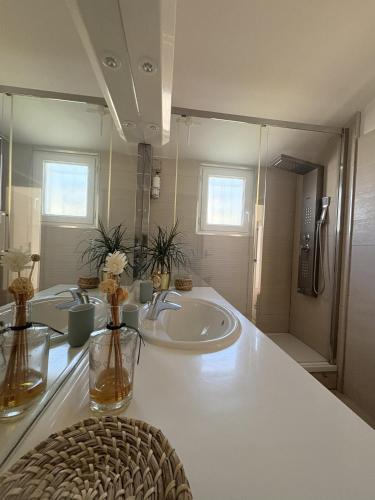a white bathroom with a sink and a mirror at Holidays font mourrier in Cogolin
