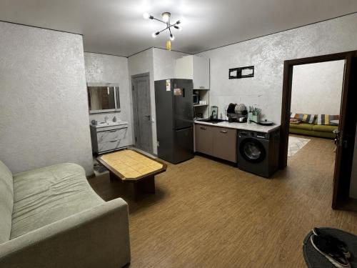 a living room with a couch and a kitchen at Дом у Озера in Priozersk