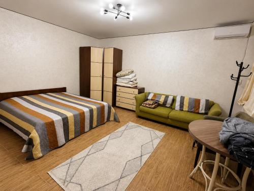 a bedroom with a bed and a couch at Дом у Озера in Priozersk