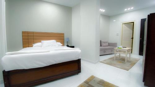 a bedroom with a large bed and a living room at Grand Hotel Qena in Qinā