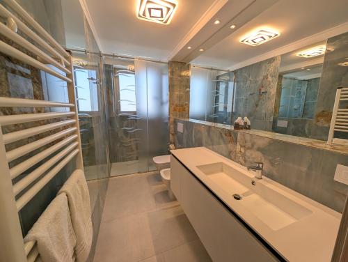 a bathroom with a sink and a toilet at Nashira Apartments in Lignano Sabbiadoro