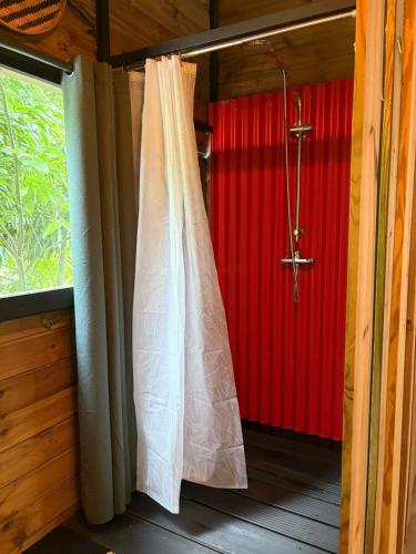 a shower curtain in a room with a red wall at River House superbe vue- vue et accès directe sur la rivière et baignade dans les bassins naturels in Saint-Joseph