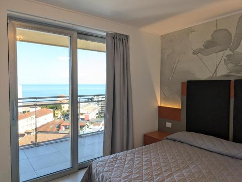 a bedroom with a bed and a view of the ocean at Nashira Apartments in Lignano Sabbiadoro