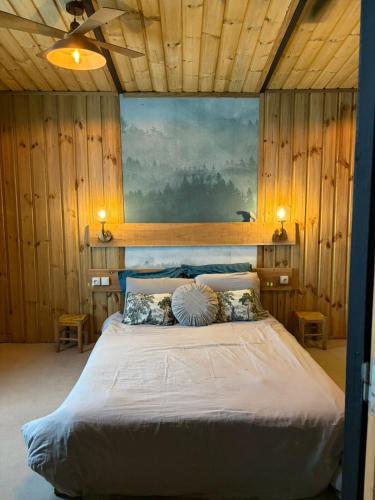 a bedroom with a large bed in a room with wooden walls at River House superbe vue- vue et accès directe sur la rivière et baignade dans les bassins naturels in Saint-Joseph