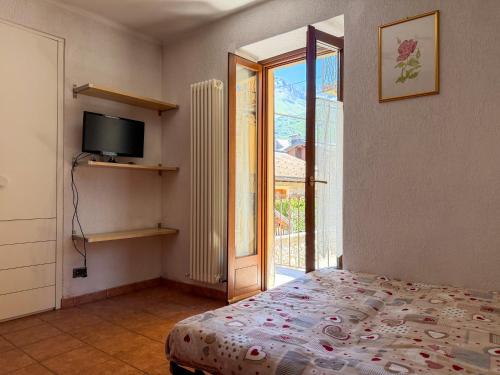 a bedroom with a bed and a tv and a window at Casa dello sciatore in Limone Piemonte