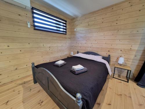 a bedroom with a bed in a room with wooden walls at Tiny House Chimay in Chimay