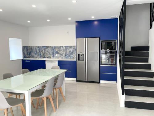 a kitchen with a white table and blue walls at Casa das Abelhas in Arcos de Valdevez