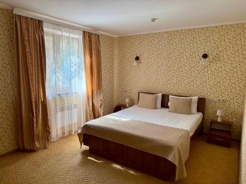 a hotel room with a bed and a window at Вілія in Lomacineţi
