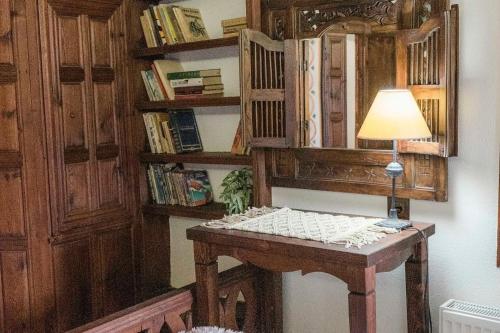 a lamp on a table in a room with books at Конак Буката in Bukata