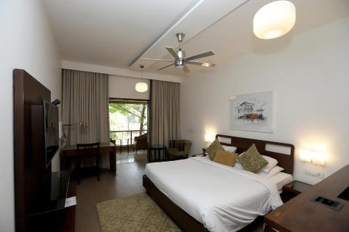 a bedroom with a bed and a ceiling fan at Trance Sunderban Resort in Pune