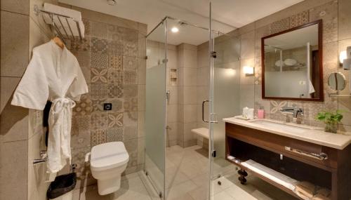 a bathroom with a shower and a toilet and a sink at Trance Sunderban Resort in Pune