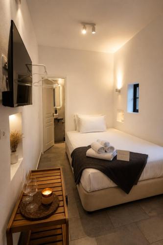 a hotel room with a bed and a table with towels at VR Chora Apartments in Serifos Chora