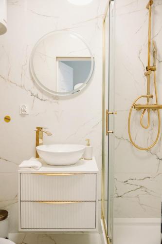 a bathroom with a sink and a mirror at Złote Apartamenty Kłodzko in Kłodzko