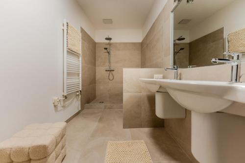 a white bathroom with a sink and a shower at Hakuna Marktquartier 9 - Terrassenwohnung Spitz in Spitz