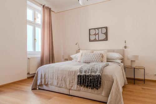 a white bedroom with a bed and a window at Hakuna Marktquartier 9 - Terrassenwohnung Spitz in Spitz