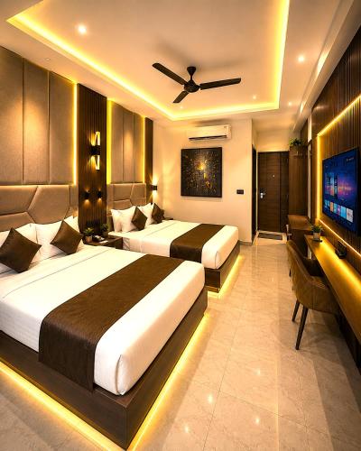 a hotel room with two beds and a flat screen tv at Premium Hotel EXO-Near Temple and Ghat#Parking and Comfort Stay#Premium Service in Varanasi
