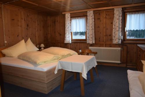 ein Schlafzimmer mit einem Bett und einem Tisch darin in der Unterkunft Haus Sonnenhof in Kappl